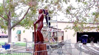 Casey McCaughn sanding her 14-foot sculpture of Engineer Casey Jones