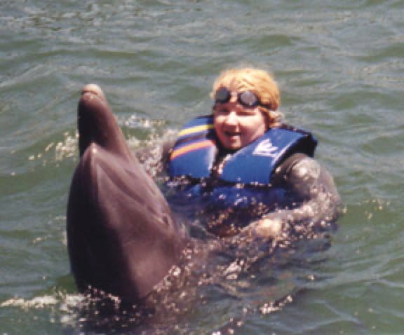 Casey McCaughn swimming with the dolphins